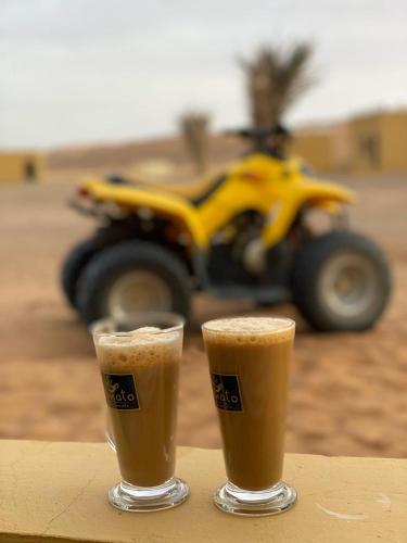 ḨawīyahにあるAL hawiyah campのオートバイを背景にしたテーブルでのコーヒー2杯