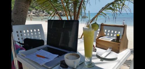 a laptop computer sitting on a table on the beach at Penthouse Crystal Bay Apartments in Ban Lamai