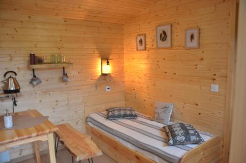 een kamer met een bed in een houten muur bij Le camp du fauconnier in La Pommeraie-sur-Sèvre