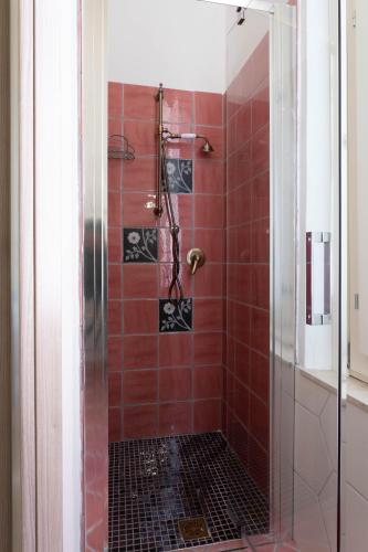 a bathroom with a shower with red tile at Maison Belle Époque & suites in Oristano