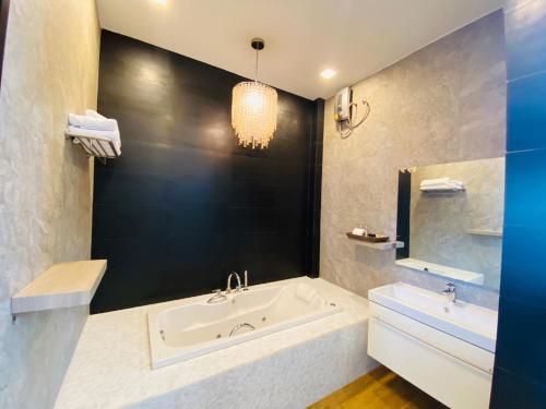 a bathroom with a tub and a sink and a mirror at Belong Jin The Dam Hotel And Resort in Ban Pha Saeng Lang