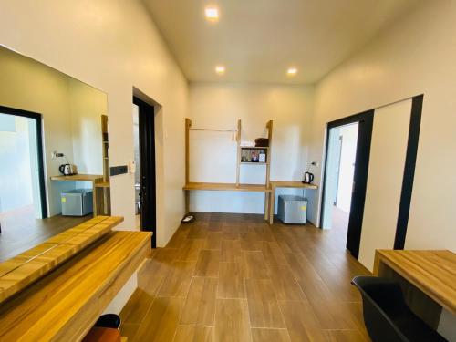 a room with wooden floors and a room with a white wall at Belong Jin The Dam Hotel And Resort in Ban Pha Saeng Lang