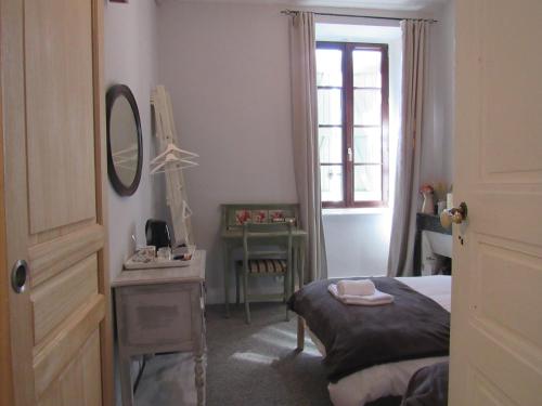 a bedroom with a bed and a mirror and a table at Les Deux Rives in Cierp