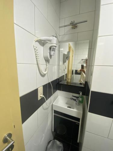 a bathroom with a hair dryer and a sink at Fly inn Hotel Lounge in Machelen