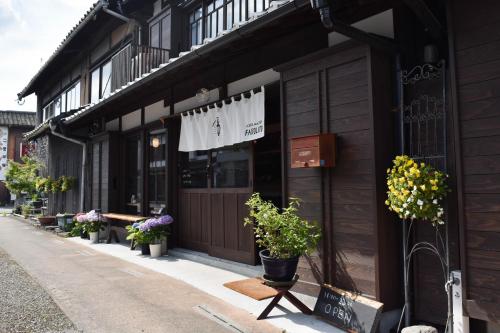 uma loja com vasos de plantas ao lado de um edifício em Hostel&Cafe Farolito em Ukiha