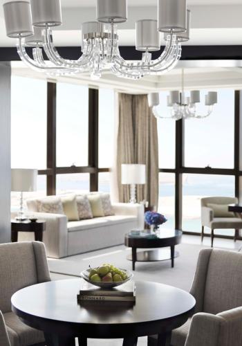 a living room with a chandelier and a table at Bab Al Qasr Hotel in Abu Dhabi