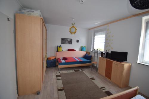 Zimmer mit einem Schlafzimmer mit einem Bett und einem TV in der Unterkunft 2-Zimmer-Ferienwohnung "Gärten der Welt" in Berlin