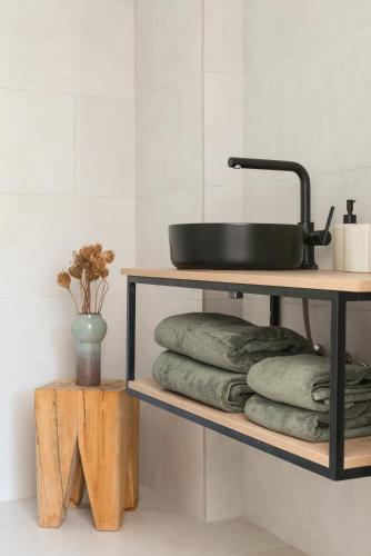 a shelf with towels and a sink on top at The Olive Boutique Suites & Spa in Cala Llonga