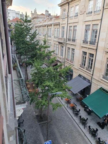 a view of a building with a tree and tables at Central & Charming Clérigos Appartments in Porto
