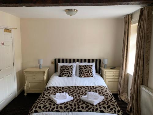 a bedroom with a bed with two towels on it at The Silk House in Leek