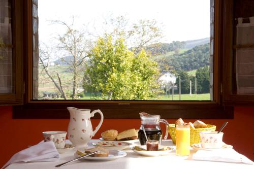 a table with plates of food and a window at Hotel Rural Suquin in Navia