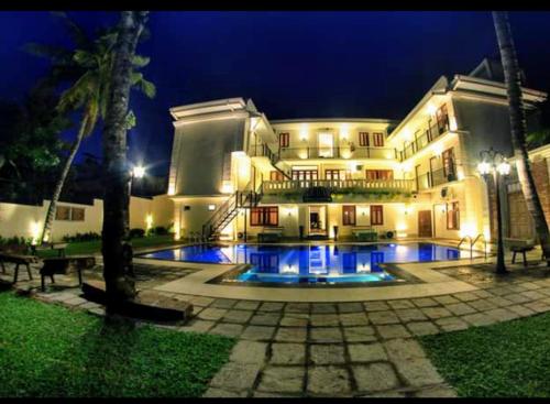 - un grand bâtiment avec une piscine la nuit dans l'établissement Forever City Hotel, à Kiribathgoda
