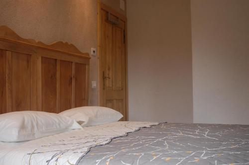 a bedroom with a bed with white sheets and pillows at B&B Il Crogiolo in Bosentino