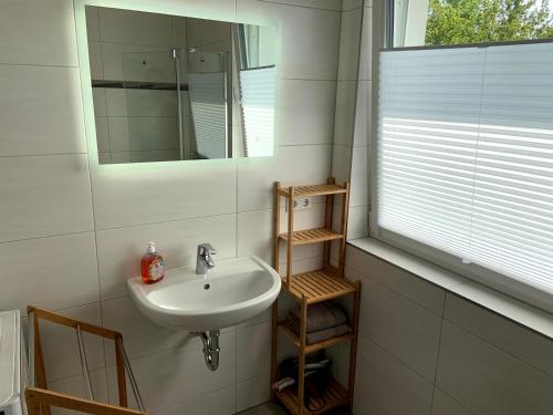 y baño con lavabo y espejo. en Ferienwohnung im Stadtzentrum, en Hennigsdorf