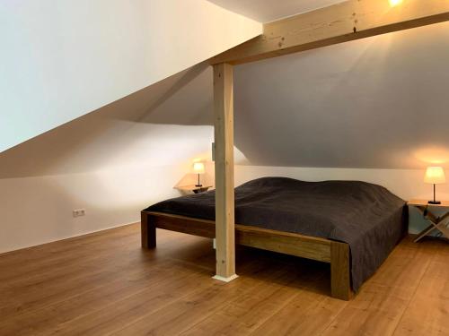 ein Schlafzimmer mit einem Bett im Dachgeschoss mit zwei Lampen in der Unterkunft Ferienwohnung im Stadtzentrum in Hennigsdorf