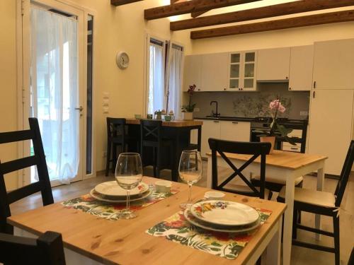 a kitchen and dining room with a table and two wine glasses at le scuderie di s.Bakhita in Schio