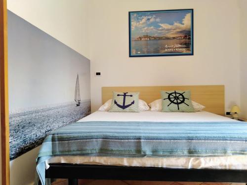 um quarto com uma cama com um quadro na parede em Guesthouse ROCK & ROLL em Rovinj