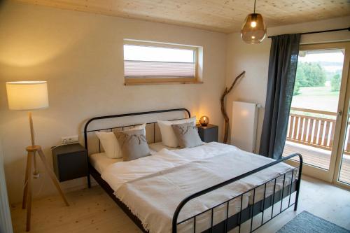 een slaapkamer met een bed met witte lakens en een raam bij Heimat-Raum in Bayersoien