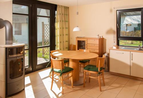 eine Küche mit einem Holztisch und Stühlen in der Unterkunft Ferienhaus Plau am See in Wassernähe in Plau am See