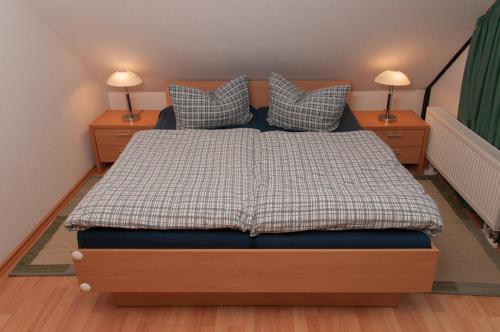 a bedroom with a bed with two night stands and two lamps at Ferienhaus Plau am See in Wassernähe in Plau am See