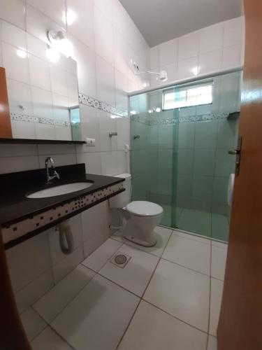 ein Badezimmer mit Toilette und Glasdusche in der Unterkunft Hotel Samambaia in Indiara 