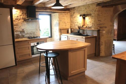 une cuisine avec un îlot en bois au milieu dans l'établissement Chambre spacieuse dans maison de caractère, au calme, avec belle vue, à Saint-Cirgues