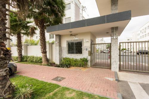 カンポス・ドス・ゴイタカゼスにあるLua E Agua Xの門とヤシの木がある家