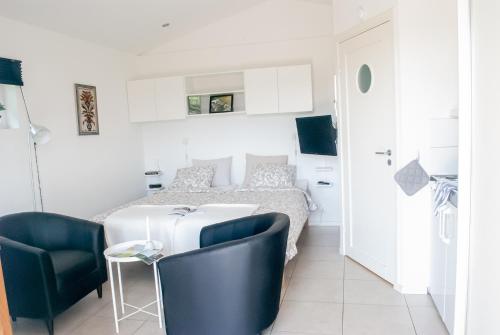 a bedroom with a bed and two blue chairs at Nordanå Gård in Strö