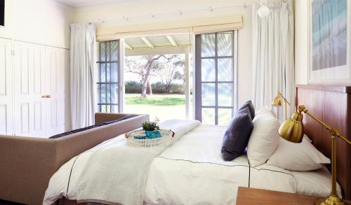 a bedroom with a bed and a couch and a window at Cherubino Wines Guest Houses in Wilyabrup
