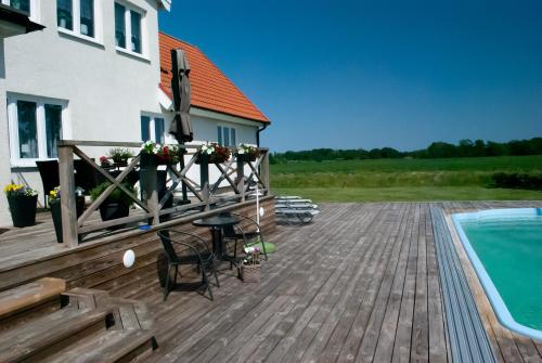a deck with a pool and a table and chairs at Nordanå Gård in Strö