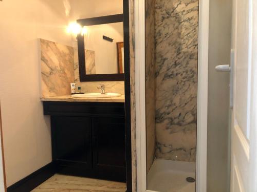 een badkamer met een wastafel en een spiegel bij Residence Soleil des Thermes 2 in Le Mont-Dore