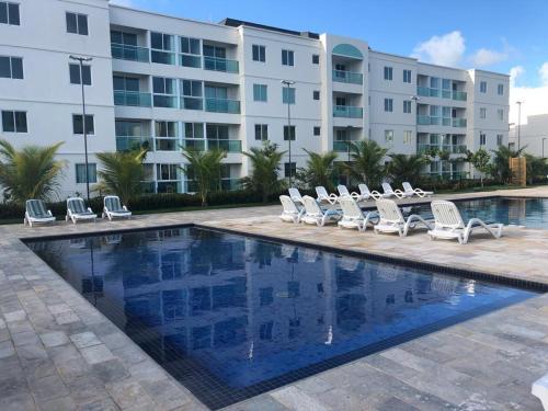 a pool with lounge chairs and a building at APARTAMENTO EM PORTO DE GALINHAS in Recife