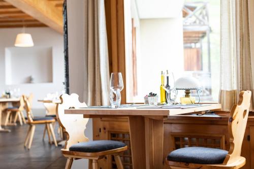 a wooden table with chairs and a window at Meisser Lodge in Guarda