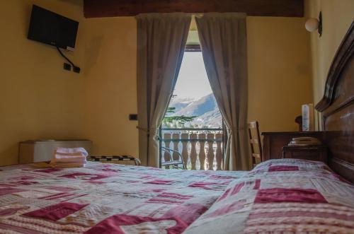 a bedroom with a bed and a view of a mountain at Hotel Chez Toi in Oulx