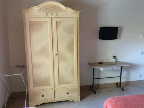 a wooden cabinet in a bedroom with a table at Tenuta San Marcello in San Marcello