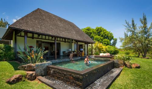 two people in a swimming pool in a backyard at Four Seasons Resort Mauritius at Anahita in Beau Champ