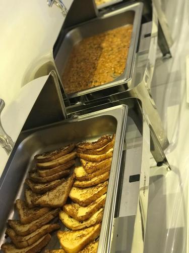 two trays of food in a display case at Home Station Hotel in Muscat