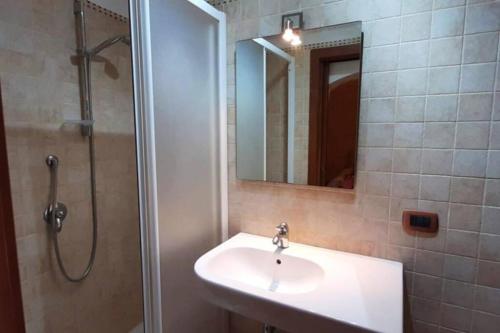 a bathroom with a sink and a shower and a mirror at Trullo Pentimelle in Martina Franca