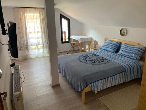 a bedroom with a bed and a television and a piano at La Măriuca in Bicaz