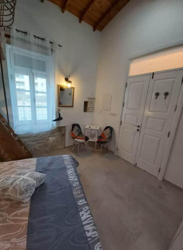 a bedroom with a bed and two chairs and a table at Magdalene's City House Inn in Larnaka