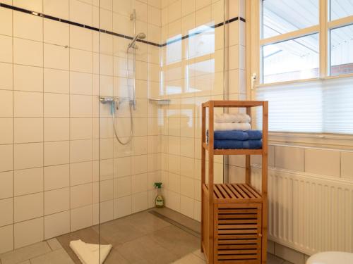 a bathroom with a shower and a towel rack at Haus Seeschwalbe in Spiekeroog
