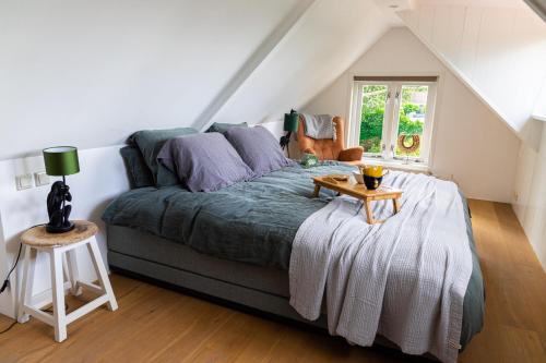 a bedroom with a bed with a table on it at Gastenverblijf KortVertoef in Kortenhoef