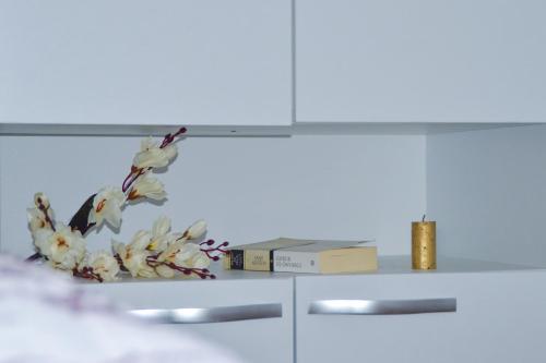 a white cabinet with a vase of flowers on it at Apartman “Centar Jajce “ in Jajce