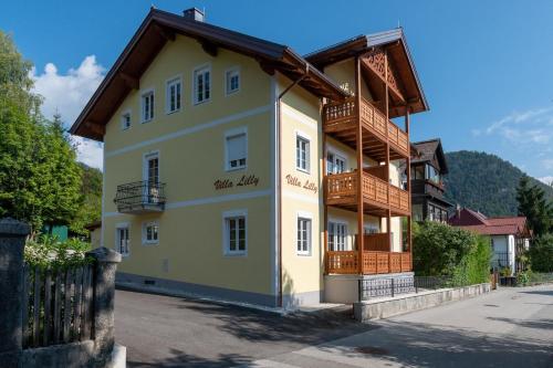 a large yellow building with a wooden roof at Villa Lilly - Luxus Appartements im Villenviertel in Bad Ischl