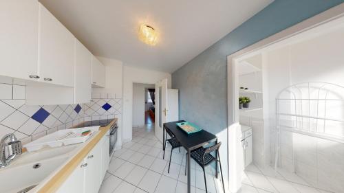 uma casa de banho branca com um lavatório, uma banheira e uma mesa em Le 22 Ehrmann em Estrasburgo