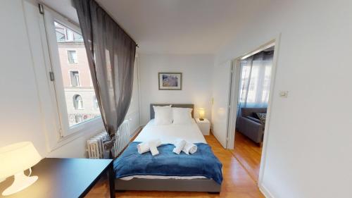 a bedroom with a bed and a large window at Le 22 Ehrmann in Strasbourg