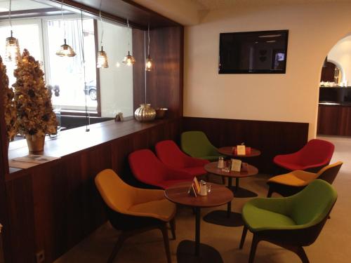 a restaurant with red and green chairs and tables at Hotel Garni & Appartements Ilgerhof in Walchsee
