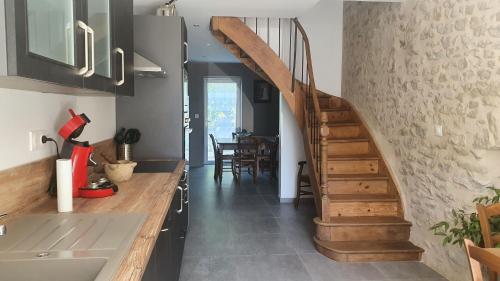 una cocina con una escalera de caracol en una casa en Aux Portes Du Marais, en Ceyzérieu