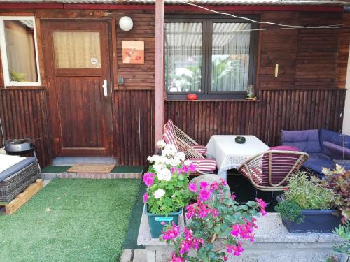 a patio with two chairs and a table and flowers at Pension Becker Luckenwalde in Luckenwalde