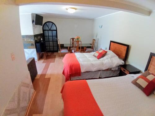 a hotel room with two beds and a dining room at Hotel Huasco in Huasco